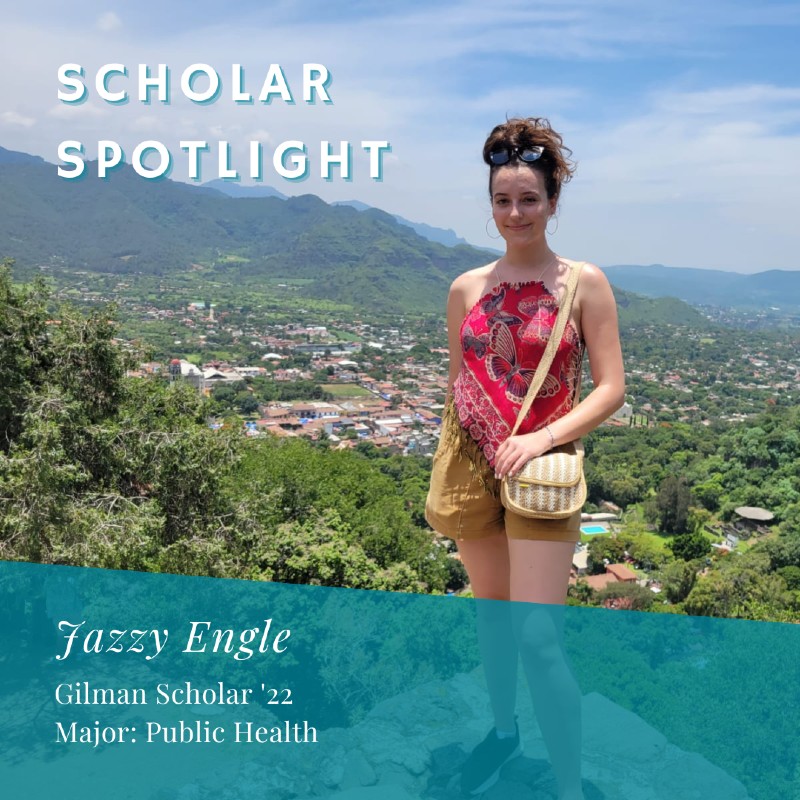Jazzy Engle Scholar Spotlight: Jazzy stands on a rock overlooking a valley with trees and buildings